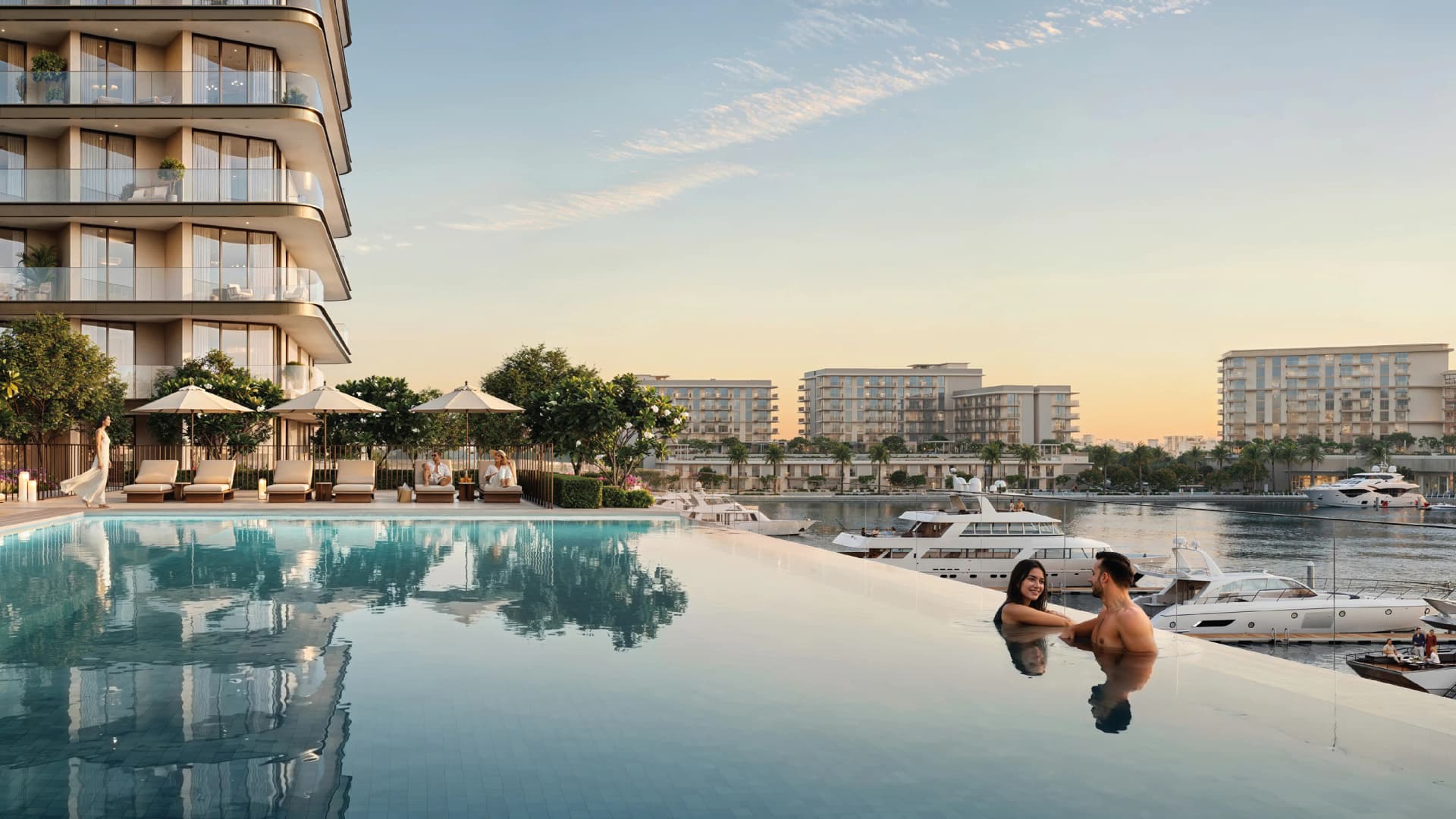 Couple in an infinity pool overlooking the yacht marina at Rashid Yachts & Marina by Emaar, Dubai, at sunset