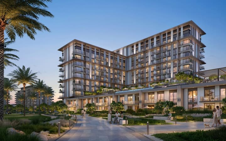 Modern residential tower with landscaped courtyard and palm trees at twilight in Emaar South